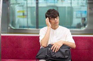 冷房の効いた室内で肌寒さを感じ、耳のこもりや不調を気にしている様子を表した写真
