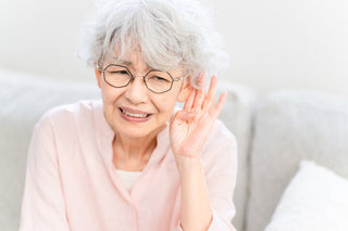 自宅で手軽にできる聴力セルフチェックをしながら、耳の聞こえ具合を確かめている人のイメージ