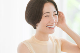 朝の身支度の合間に耳たぶを引っ張るストレッチを行う日常の一場面をイメージした写真