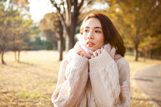 気温が下がる季節に耳の違和感を感じ、耳元を手のひらで温めている様子を表した写真