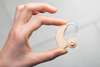 耳あな型や耳かけ型など、さまざまなタイプの補聴器を装着して快適さを比べている様子の写真