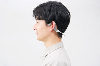 こめかみに骨伝導集音器を当てる様子を写した、鼓膜を介さず音を届ける仕組みを表すイメージ