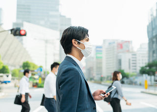 マスクをつけた人々が会話をする様子、感染症と聴覚の健康との関わりを考えさせる一枚