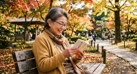 9月29日の秋の読書シーズンに、老眼鏡と耳掛け式集音器を快適に併用して笑顔を見せるシニア。メガネと集音器を重ね掛けする正しい順番（集音器が先・メガネが後）と、耳が痛くならないMimitakara超軽量集音器の活用法を解説するイメージ。