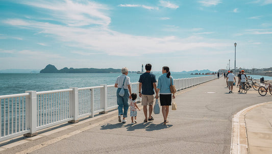 夏休みに孫と一緒に海辺やプールでお出かけを楽しむシニア夫婦。水遊び時の集音器のうっかり水没を防ぐ注意点や、潮風による塩分・べたつきを防ぐお手入れ方法、緊急時の正しい乾燥ケアを解説するイメージ。